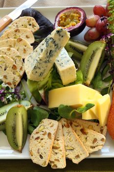 Delicious fruit and cheese platter featuring a variety of different cheeses and fresh fruits.