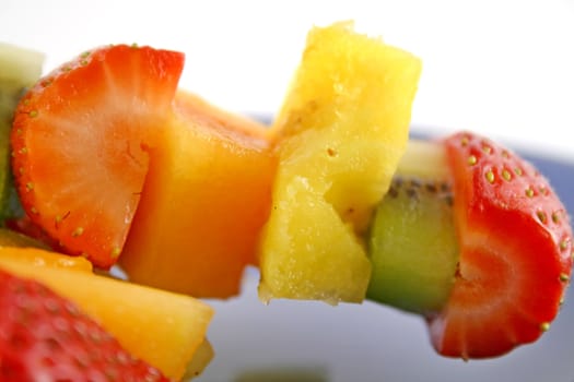 Colorful kebabs made with skewers of fresh fruit pieces.