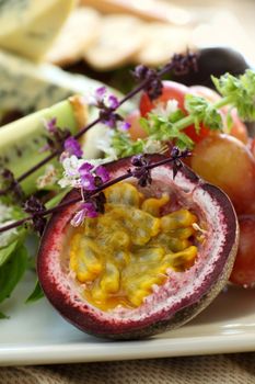 Delicious passionfruit with fresh grapes, basil flowers and a variety of cheeses.