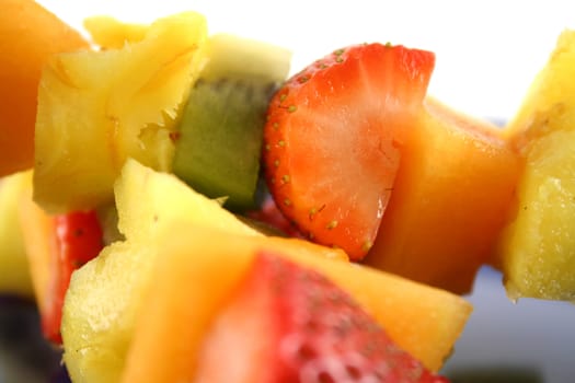 Colorful kebabs made with skewers of fresh fruit pieces.