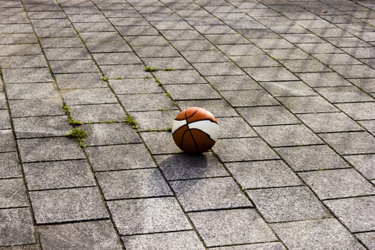 Basketball ball on the playground in sunlight