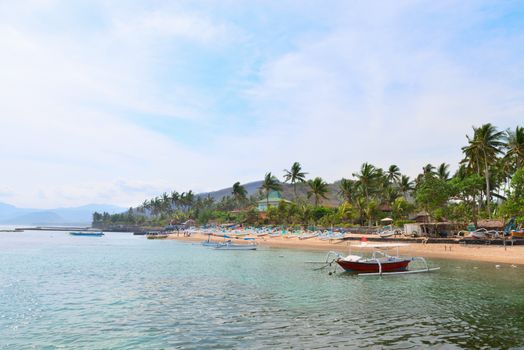 Sea shore on Bali in Candidasa with traditional wooden fishing boats on a beach