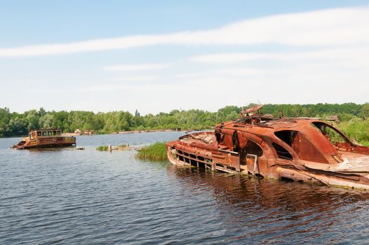 Wrecked abandoned ships on a river after nuclear disaster in Chernobyl, Ukraine