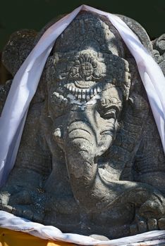 Stone sculpture of hindu god Ganesha with white veil