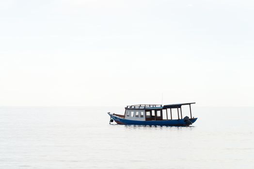 Lonely blue wooden motorboat on a calm sea