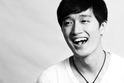 Portrait of young man laughing out loud, black and white style