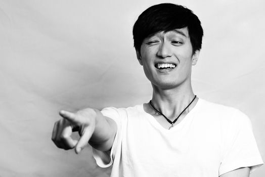 Portrait of condescending young man pointing and laughing, black and white style