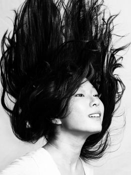 Portrait of beautiful young woman flicking her hair and posing, black and white style