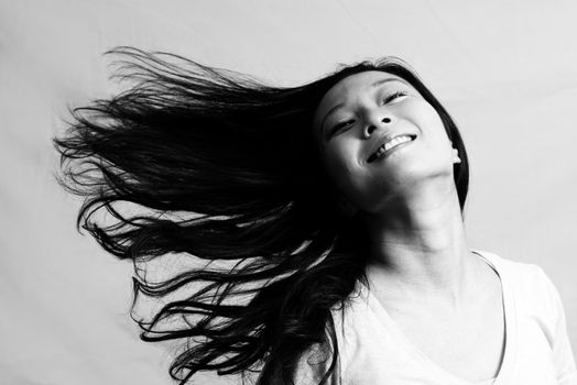 Portrait of beautiful young woman flicking her hair and posing, black and white style