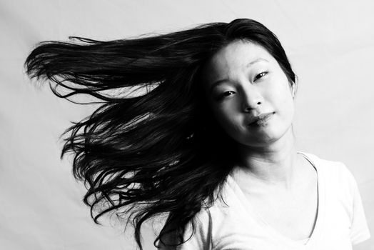 Portrait of beautiful young woman flicking her hair and posing, black and white style