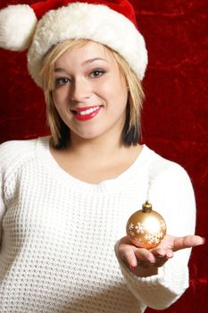 A beautiful woman holds a Christmas bauble as she gets ready to decorate.