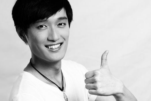 Portrait of young man gives thumbs up, black and white style