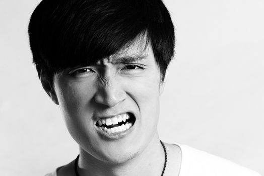 Portrait of young man looking angry and yelling, black and white style