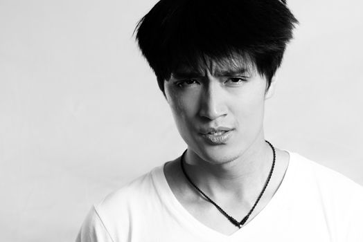 Portrait of handsome young man looking upset and flicking hair, black and white style