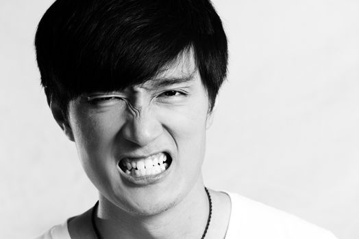 Portrait of young man looking angry and yelling, black and white style