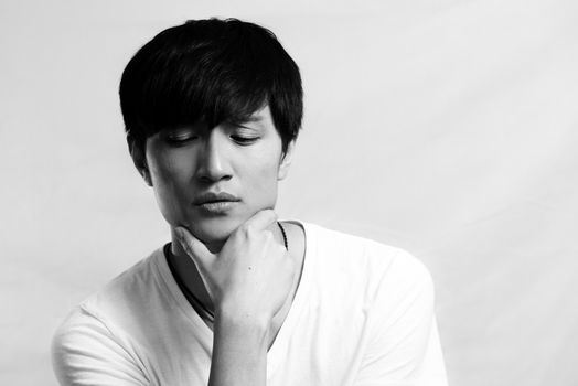 Portrait of handsome young man looking deep in thought, black and white style