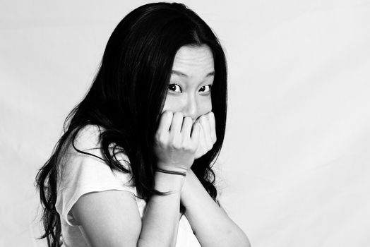 Portrait of cute young woman covering her face, black and white style