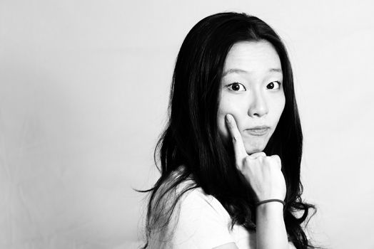 Portrait of cute young woman with cute pose poking face, black and white style
