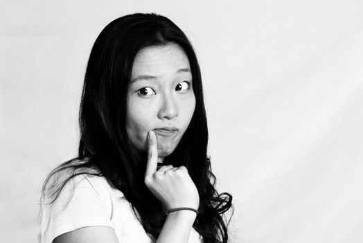Portrait of cute young woman with cute pose poking face, black and white style