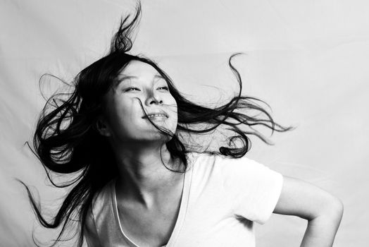 Portrait of beautiful young woman flicking her hair and posing, black and white style