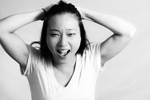Portrait of young woman pulling her hair in frustration, black and white style