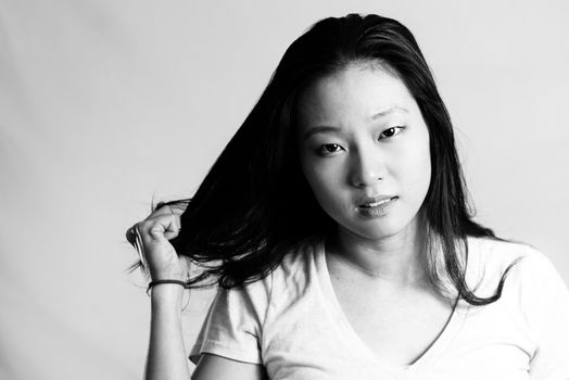 Portrait of young woman pulling her hair in frustration, black and white style