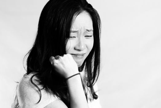 Portrait of young woman crying while pulling her hair, black and white style
