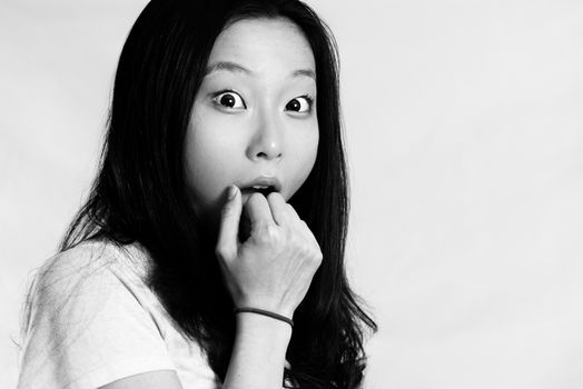 Portrait of young woman looking shocked and covering her mouth, black and white style