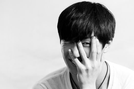 Portrait of handsome young man smiles and looking shy, black and white style