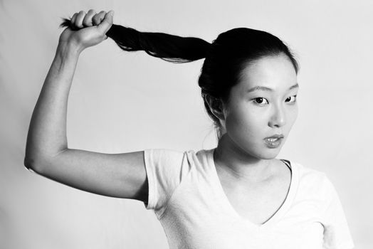 Portrait of lonely young woman pulling her hair looking frustrated, black and white style