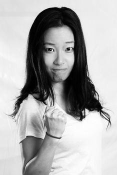 Portrait of attractive young woman clenching her fist for encouragement, black and white style