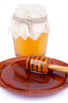 Arrangement of Wooden Dipper with Honey into Brown Plate and Glass Jar with Flower Honey isolated on white background