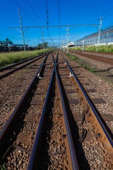 Trains railway tracks lines on stone with infrastructure outdoors.