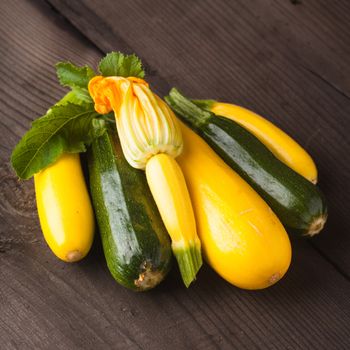 Yellow and green zucchini on the wood background