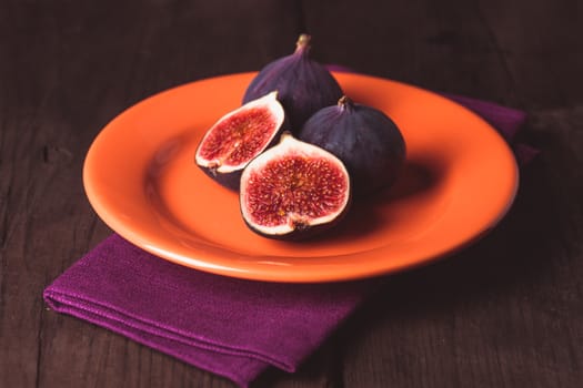 Slice of purple figs on a plate and napkin close up