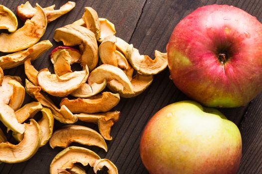 Slices of dried apples on the wooden table closeup