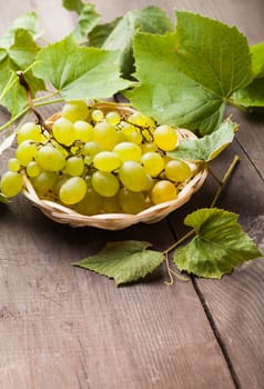 White grape with leaves in the wooven plate