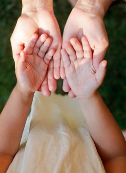 Little girl showing her hands to mother outdoors