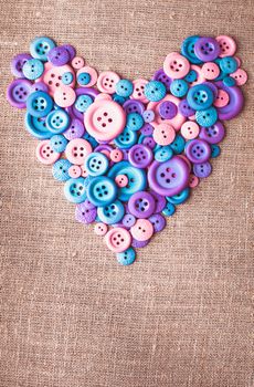 Heart shape from buttons over canvas textile