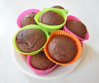 Muffins in colourful plastic cups