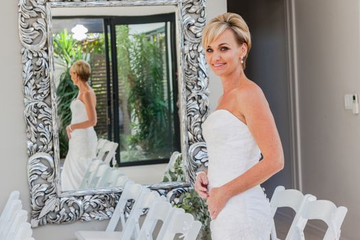 Bride with happy smiles at home ready for wedding ceremony.