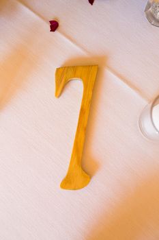 A wooden number 7 or seven is carved out of the wood at a wedding.