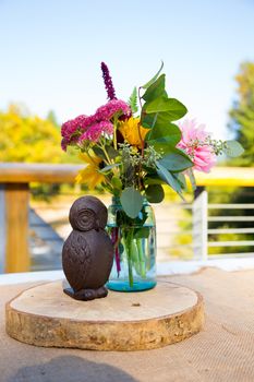 Centerpieces for this wedding include handmade wooden owls and flowers on the reception tables.