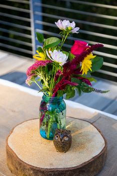 Centerpieces for this wedding include handmade wooden owls and flowers on the reception tables.