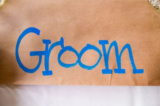 A handmade sign says groom to reserve his spot at the wedding reception.