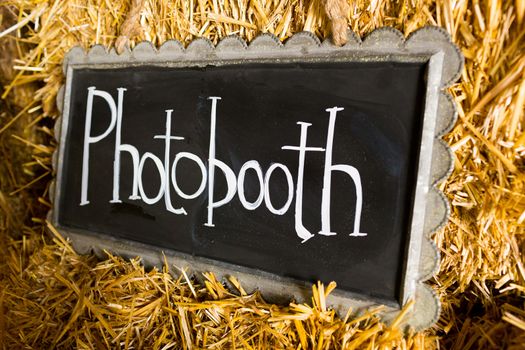 Decor at this wedding includes chalkboard signs that say photobooth or photo booth to indicate it's location at the reception.