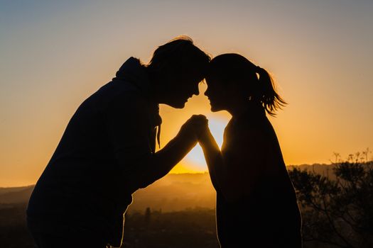 Mother daughter fun moments together silhouetted outlines at sunset.