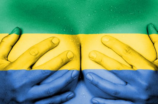 Sweaty upper part of female body, hands covering breasts, flag of Gabon