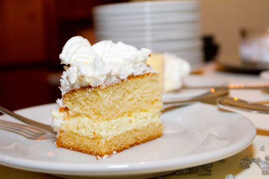 This slice of wedding cake is served on a plate ready for a guest to take and eat it.