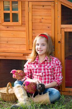 breeder hens kid girl rancher blond farmer playing with chicks in chicken tractor coop